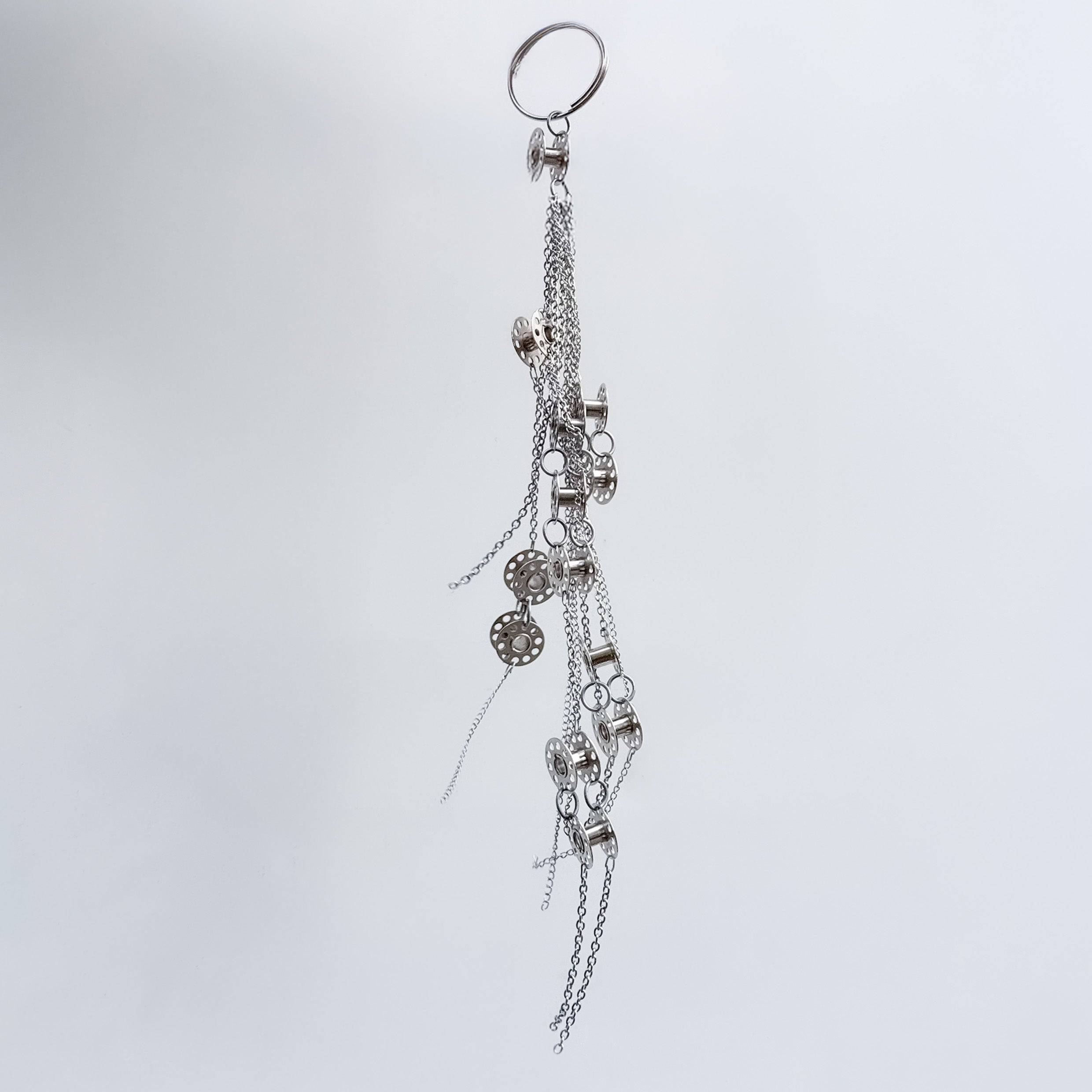 Metal bag charm on a light gray background